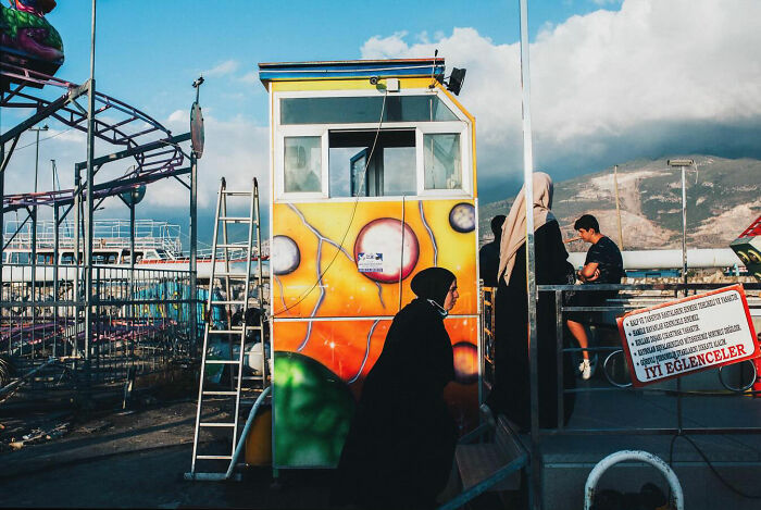Candid moment of people at a colorful amusement park booth showing the real side of life in Turkey.