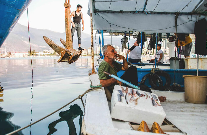 Fishermen on a boat in Turkey showcasing the candid side of life with fresh fish and relaxed daily moments by the water.