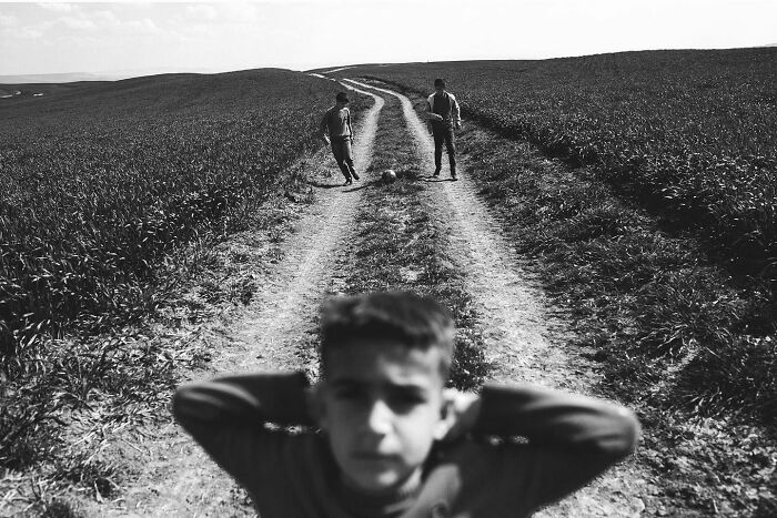 Boys playing soccer on a dirt road in rural Turkey in a candid real-life moment captured by Yusuf Aksoy.