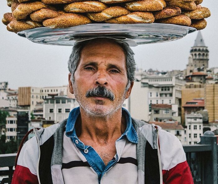 Middle-aged Turkish man carrying a tray of simit bread on his head, showcasing the real candid side of life in Turkey.