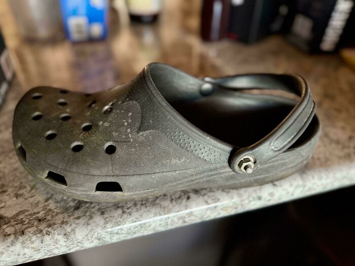 Worn black clog on kitchen counter illustrating funny differences between moms and dads in everyday life moments