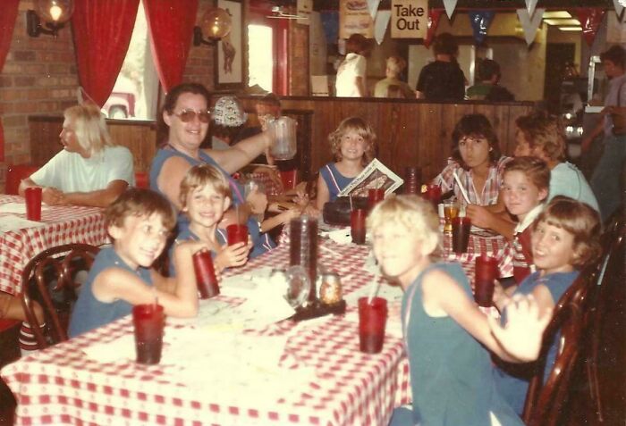 Group of kids and an adult at a vintage restaurant, evoking nostalgia and making you feel old as heck with retro vibes