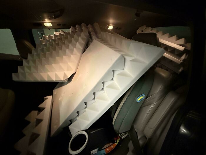 Large foam soundproofing panels salvaged from dumpster filling the backseat of a car at night.