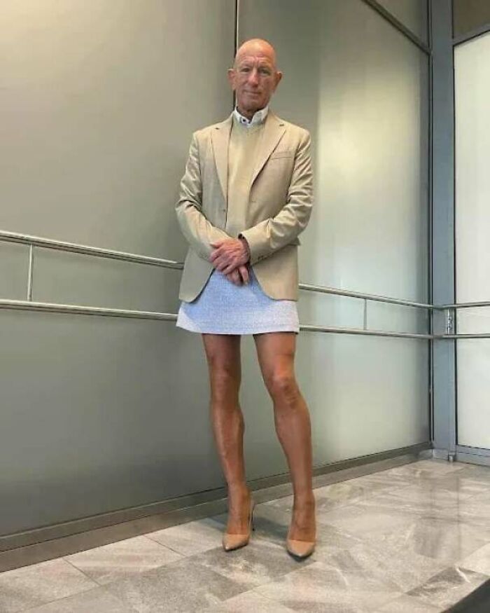 Elderly man standing confidently in a blazer and skirt, inspiring heartwarming stories to cleanse your feed.