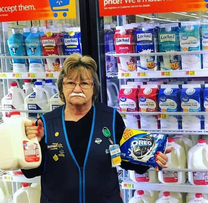 Walmart employee with milk mustache holding milk and Oreo cookies, a heartwarming moment to brighten your feed.