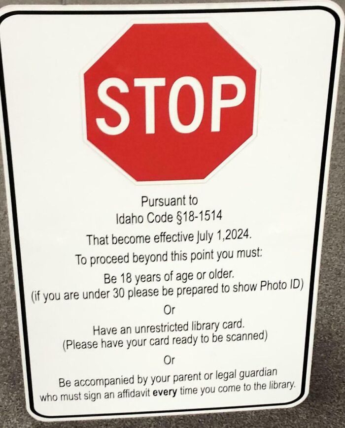 Stop sign with text detailing ID or library card requirements to enter, illustrating real-life dystopian scenes in the US.