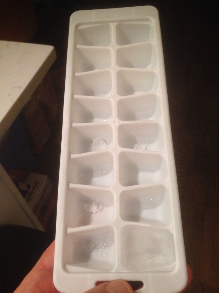 Partial ice tray with few small ice cubes in some compartments, illustrating what awful roommates people have to deal with.