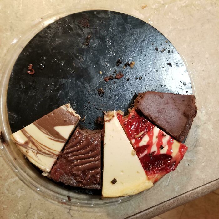 Partially eaten mixed cheesecake on a black tray left in a kitchen, illustrating awful roommates and shared living frustrations.