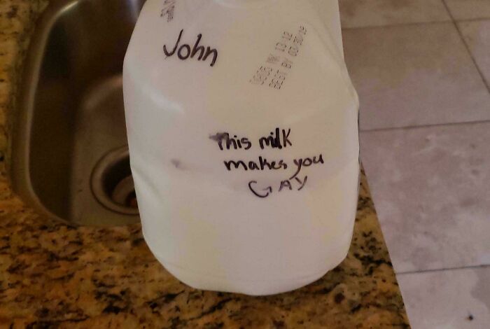 Milk jug labeled with a roommate's name and a rude message, highlighting awful roommate behavior in enraging photos.