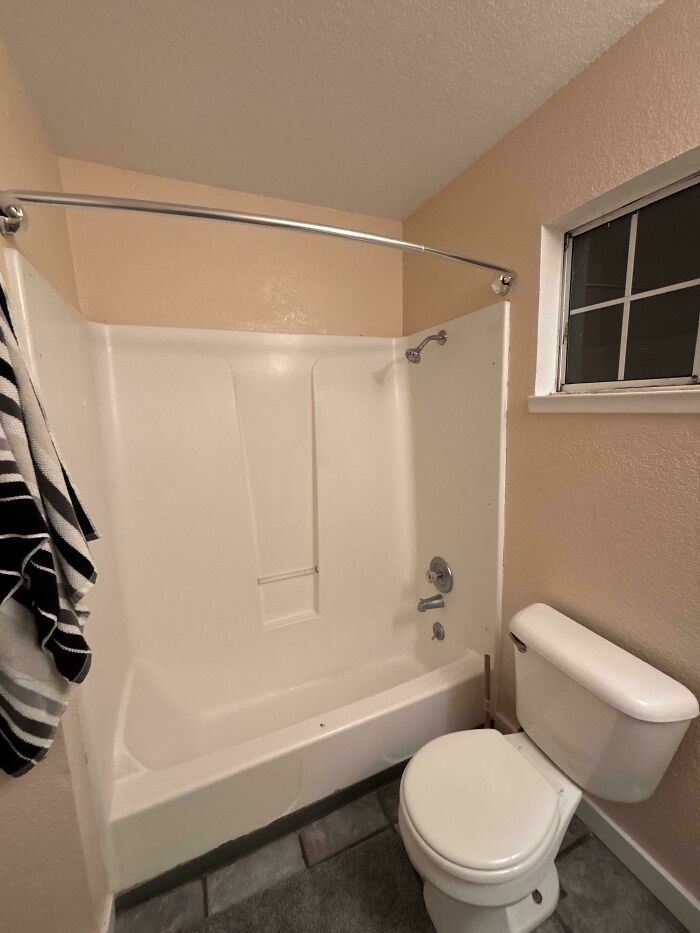 Small bathroom with bathtub and toilet showing typical issues with awful roommates and shared spaces.