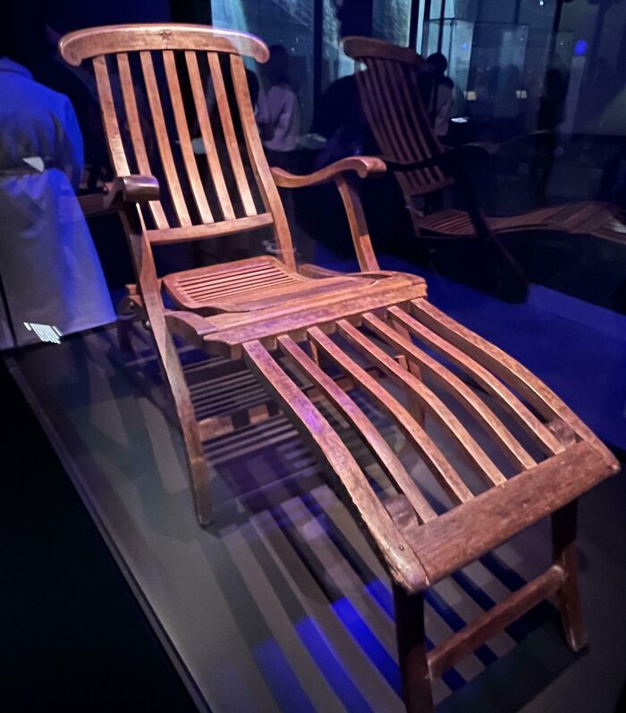 Wooden reclining deck chair from the Titanic displayed in a museum as a rare historical photo artifact.