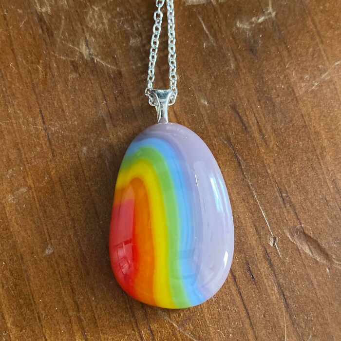 Rainbow pendant necklace on a wooden surface, capturing the colorful and wholesome vibes parents and kids share.