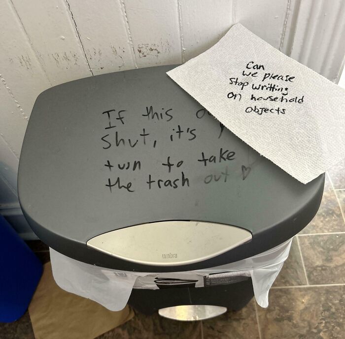 Trash can lid with roommate notes written on it and a napkin, illustrating awful roommate behavior in a shared living space.