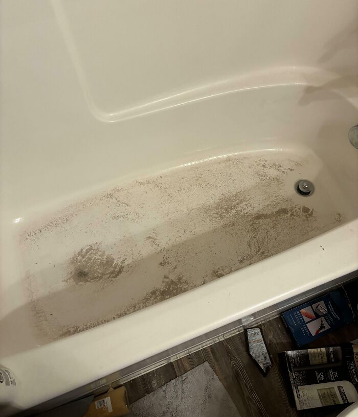 Dirty bathtub with grime buildup and cluttered floor, illustrating awful roommates people have to deal with challenges.