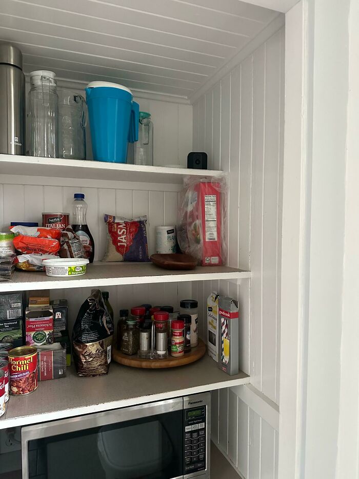 Pantry with food items and microwave showing a vacation scene with the worst luck on vacation shared pics.