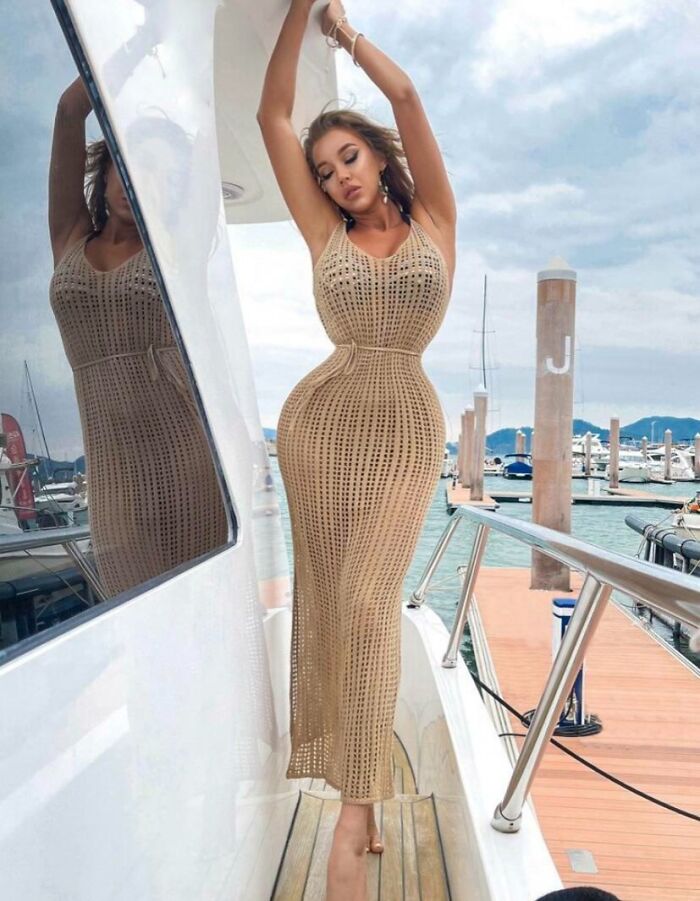 Woman posing on a yacht with an exaggerated body shape, showcasing a common social media filter fail outside.