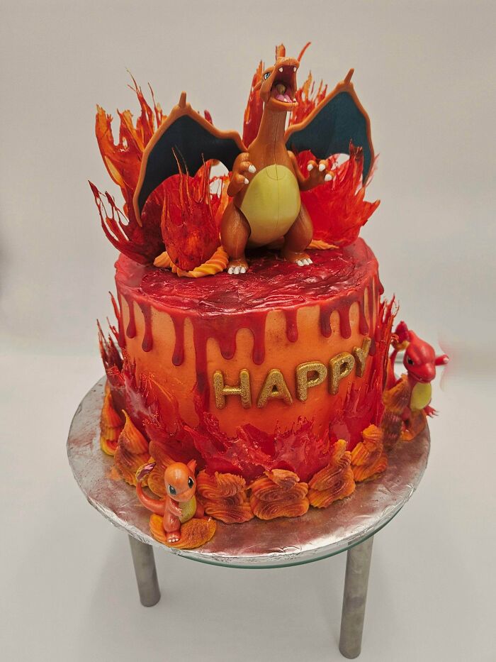 Charizard-themed cake with fiery red and orange baked goods decorations showcasing impressive baking skills.