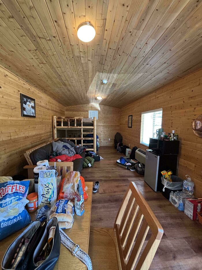 Rustic vacation cabin interior with cluttered table, bunk beds, and scattered luggage showing vacation worst luck experience.