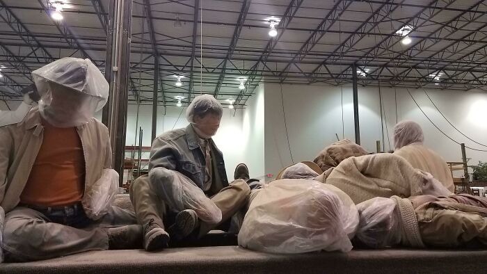 Creepy and unsettling workplace scene showing workers with covered faces in an industrial setting, highlighting jobs that should pay more.