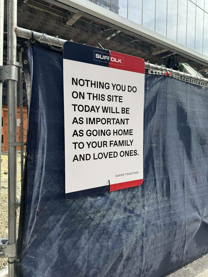 Safety sign on construction fence emphasizing worker safety and importance in jobs that should pay more.