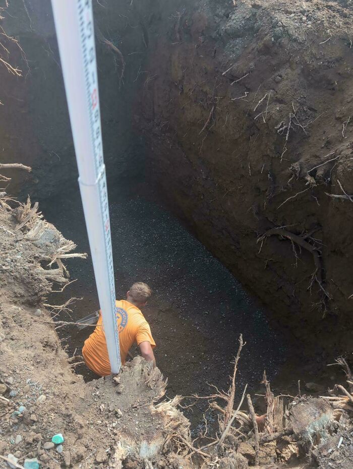 Worker in a deep hole surrounded by dirt and roots, illustrating jobs that should pay more based on unsettling photos.