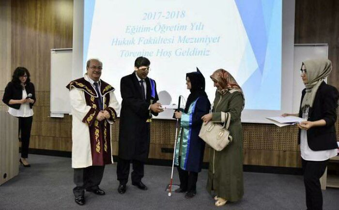 Ceremonia de graduación con abogados y familiares en un evento formal, capturando un momento inspirador y alegre.
