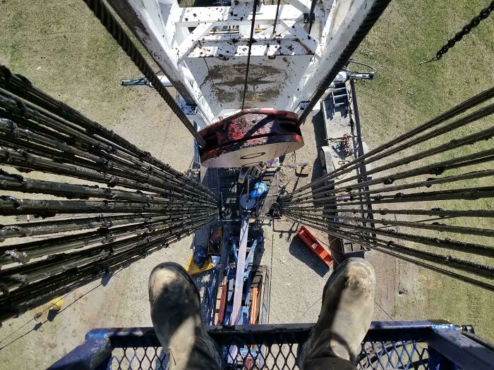 View from a high industrial structure showing worker boots and heavy equipment, illustrating jobs that should pay more.