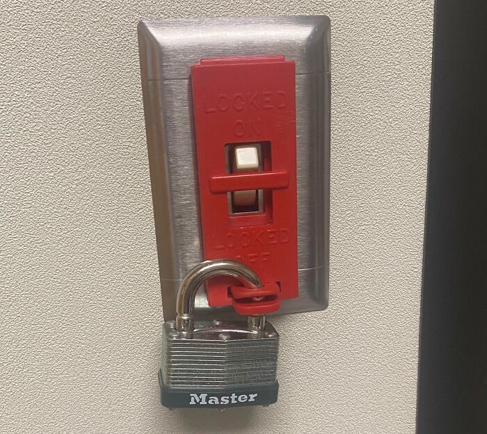 Light switch locked in off position with a Master padlock, illustrating why people hate their boss frustrations.