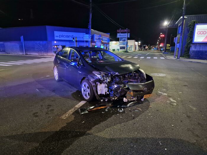 Damaged car at night in an intersection illustrating worst luck on vacation with a severe front-end crash.
