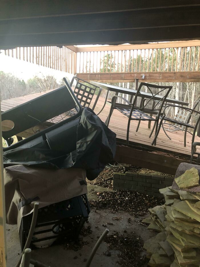 Outdoor deck with broken railing and toppled patio furniture showing worst luck on vacation incident.