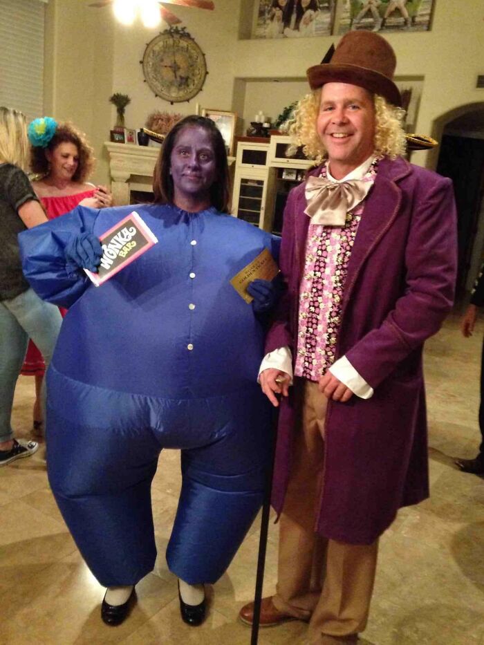 Couple dressed as Violet Beauregarde and W***y Wonka in creative costumes, showcasing funniest parents ever humor at party.