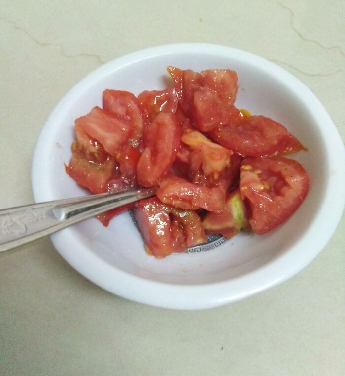 Bowl of fresh chopped tomatoes with a spoon, a wholesome moment reflecting happiness-inducing moms being their amazing selves.
