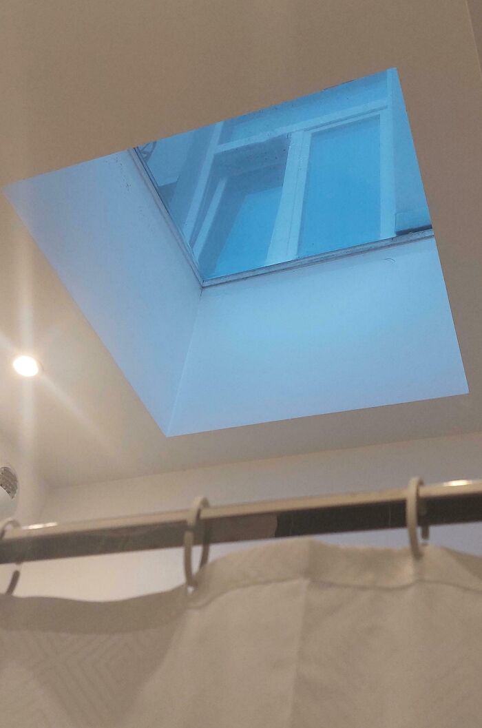 Bathroom skylight shows a window view outside, illustrating bad luck on vacation with poor bathroom design.