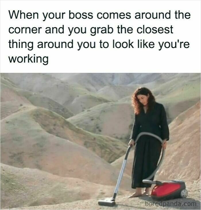 Woman pretending to work by using a vacuum cleaner in a barren outdoor setting in a work memes image.