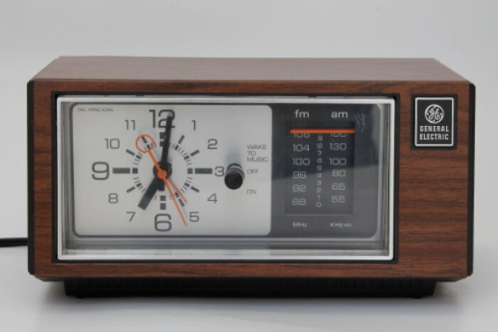 Vintage General Electric clock radio with wood paneling, showcasing old technology to make you feel old as heck nostalgia.