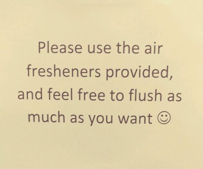 Passive-aggressive coworker note asking to use air fresheners and flush as much as desired with a smiley face.