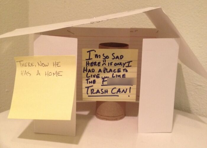 Passive-aggressive notes from coworkers with a homemade paper house around a toilet paper roll as a sarcastic gesture.