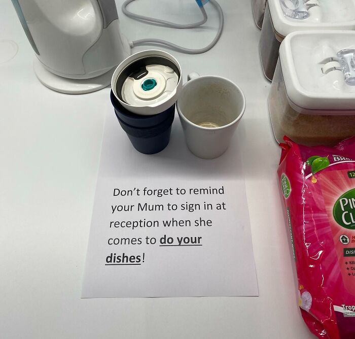 Passive-aggressive coworker note reminding to have their mum sign in at reception to do dishes with cups on a kitchen counter.