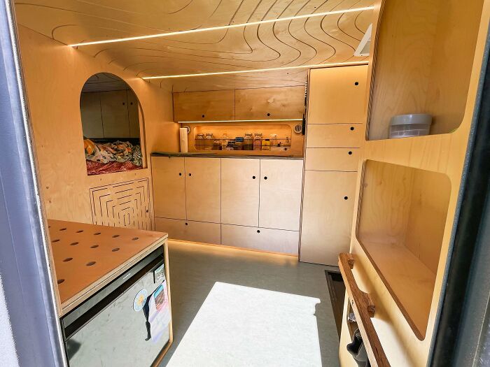 Compact wooden camper interior showcasing innovative woodworking projects with custom cabinetry and creative storage solutions.