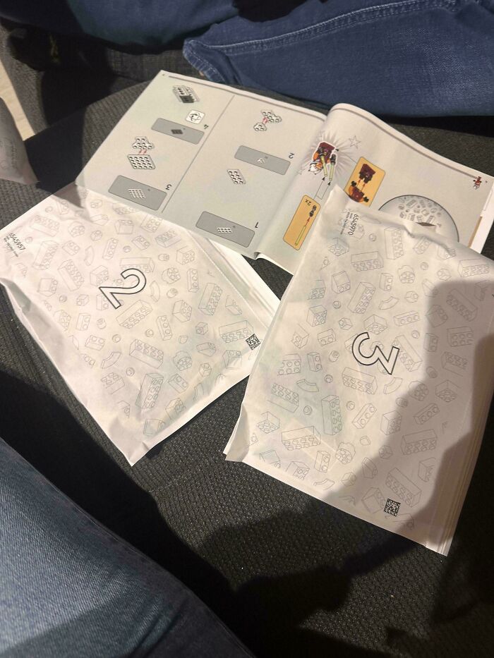 Instruction manuals and numbered packaging on a dark couch, unrelated to devil sunrise photos or scenes.