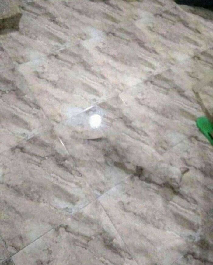 Marble floor tiles with a reflection of light creating an unusual pattern resembling devil sunrise imagery.