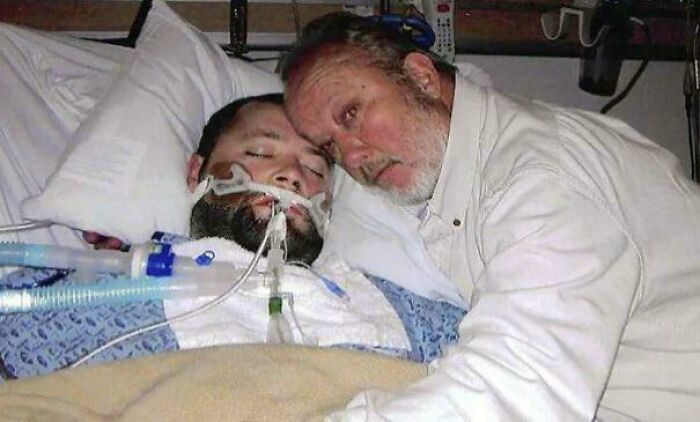 Man in hospital bed with breathing tube being comforted by an older man, highlighting facts still remain undiscovered.