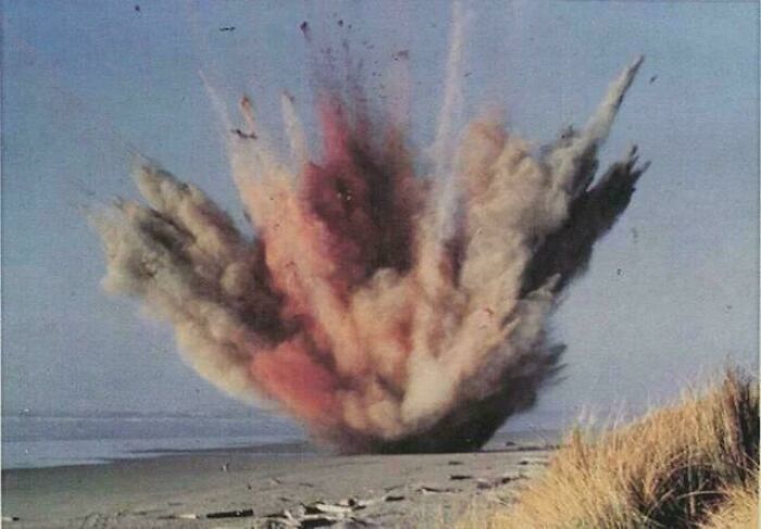 Explosion captured on a beach with smoke and debris rising, illustrating a still remains undiscovered to this day mystery.