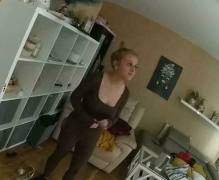 Woman standing in a cozy living room with shelves and furniture, scene still remains undiscovered to this day concept.