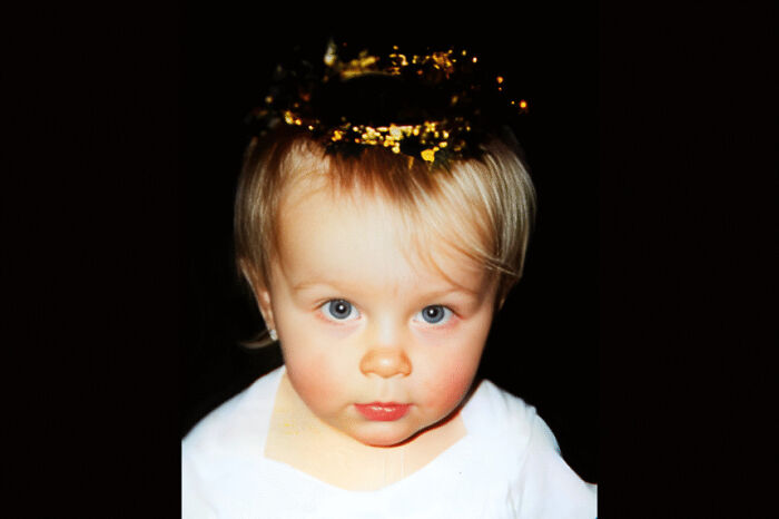 Toddler with blue eyes wearing a white shirt and a golden crown, symbolizing wonders that still remain undiscovered today.