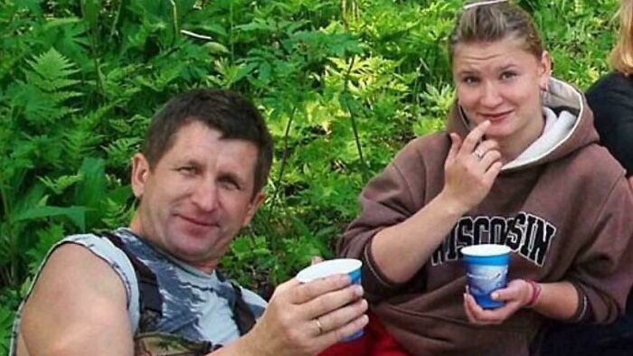 Two people outdoors holding cups, relaxing in nature surrounded by green foliage, still remains undiscovered to this day.