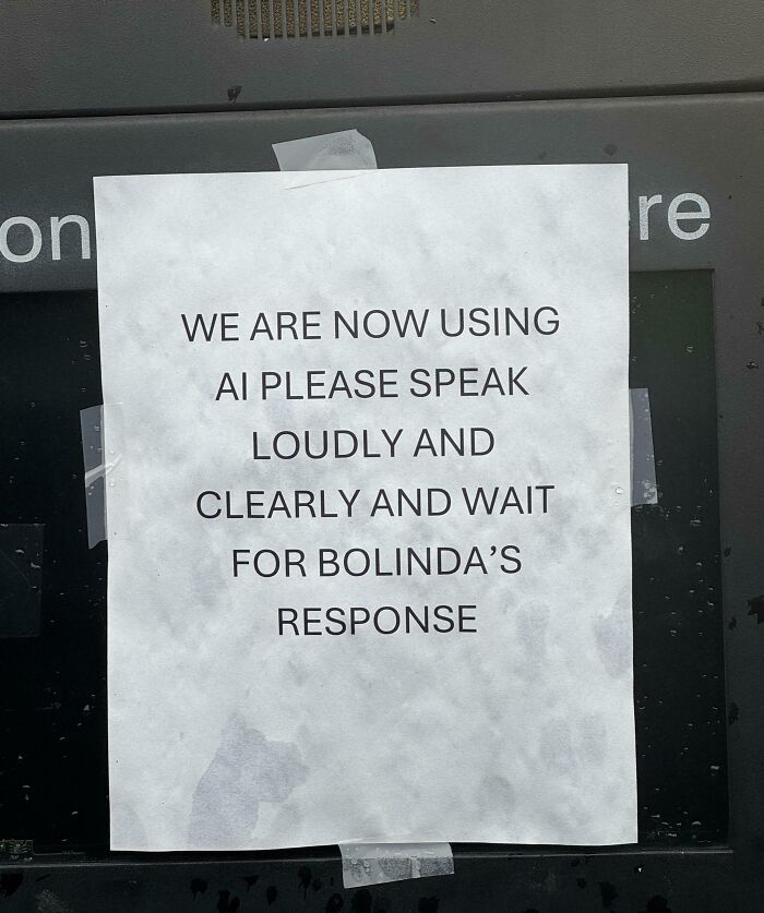 Sign taped on a machine instructing to speak loudly and clearly for AI response in a dystopian real-life scene in the US.