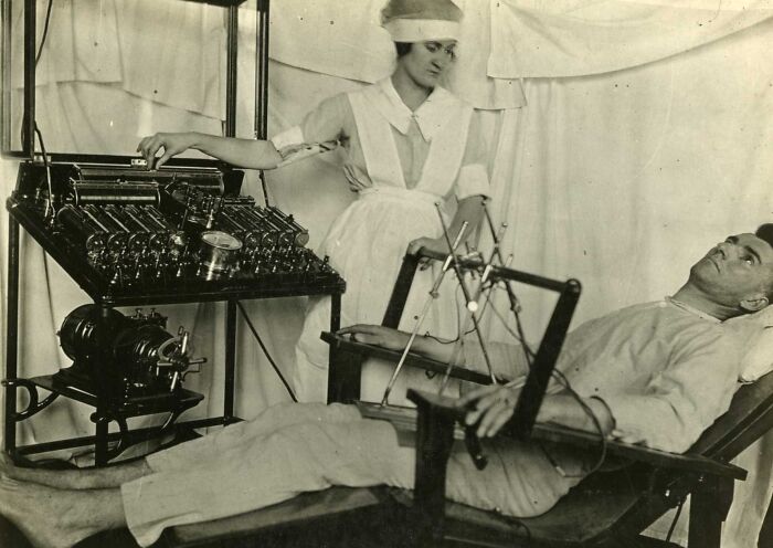 Nurse operating vintage medical device on a patient in old-school medical pics showing historical treatment methods.