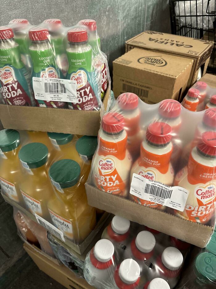 Packaged bottles of Coffee Mate Dirty Soda in unusual flavors stocked alongside various beverages, showcasing nonsensical products.