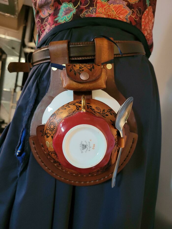 Leather belt holder carrying upside-down teacup, saucer, and spoon, showcasing one of the most nonsensical things that actually exist.